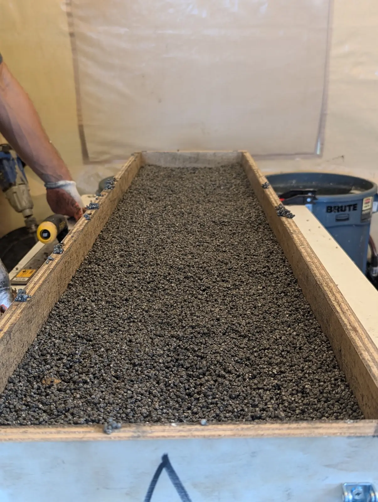 Wet foam-cement mix packed into a long wooden mold